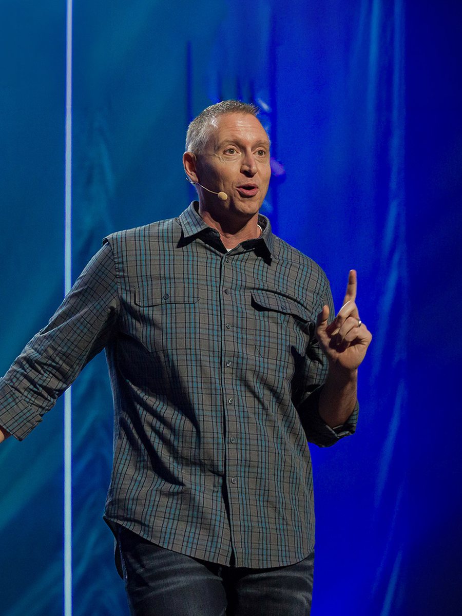 Vance Pitman preaching on stage. Opens bio.
